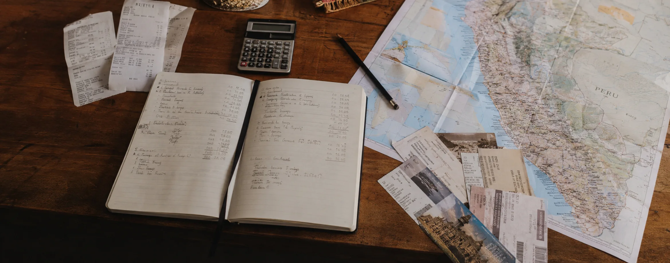 A notebook, receipts and a map spread on a table